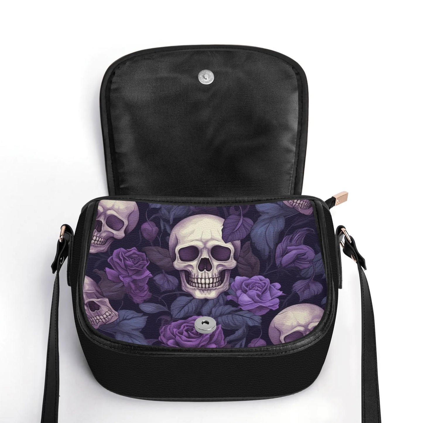 "Gothic Garden saddle handbag with skulls and purple flowers, secure closure, and adjustable strap."