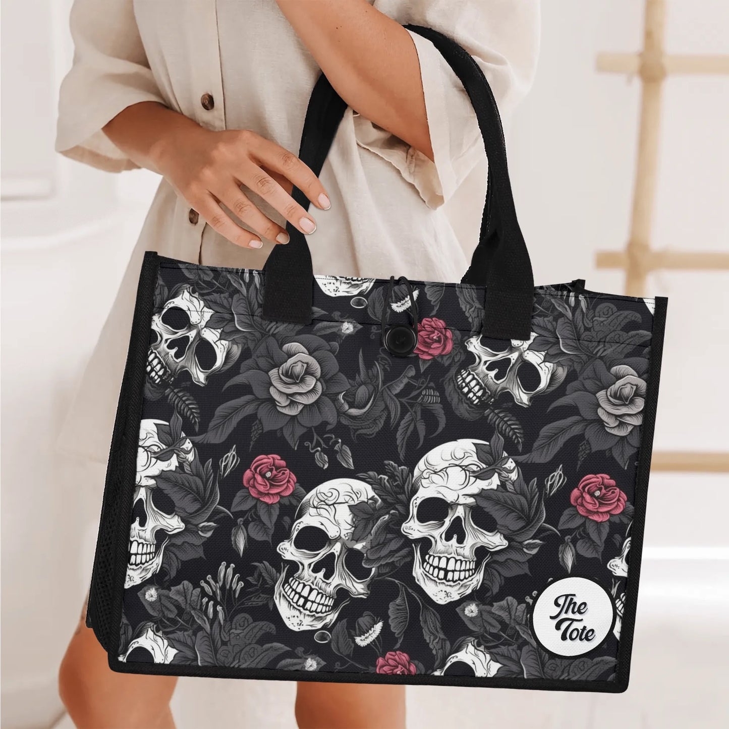 "Gothic tote bag showcasing black and white skulls with red roses, ideal for fashion lovers who embrace edgy styles."