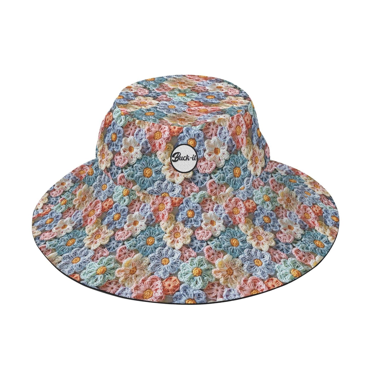 The Posy Bucket Hat featuring a delicate crochet pattern of colorful flower petals in pastel blue, peach, and pink tones, with a circular brand badge on the front. Wide-brimmed design with floral print throughout, perfect for sun protection and style.