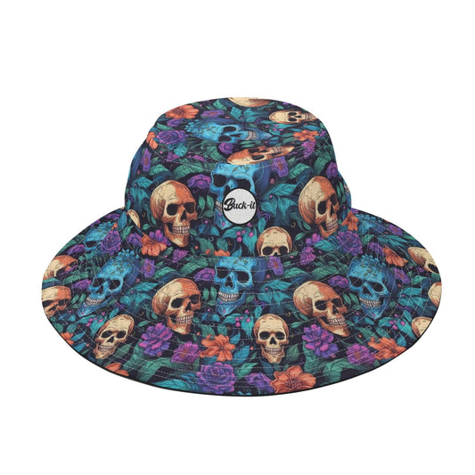 Garden Skull Bucket Hat featuring a vibrant all-over print with beige skulls, purple roses, and teal foliage on a dark background. Round white brand patch centered on the front. Wide-brimmed design with quilted texture perfect for sun protection and gothic style fashion.