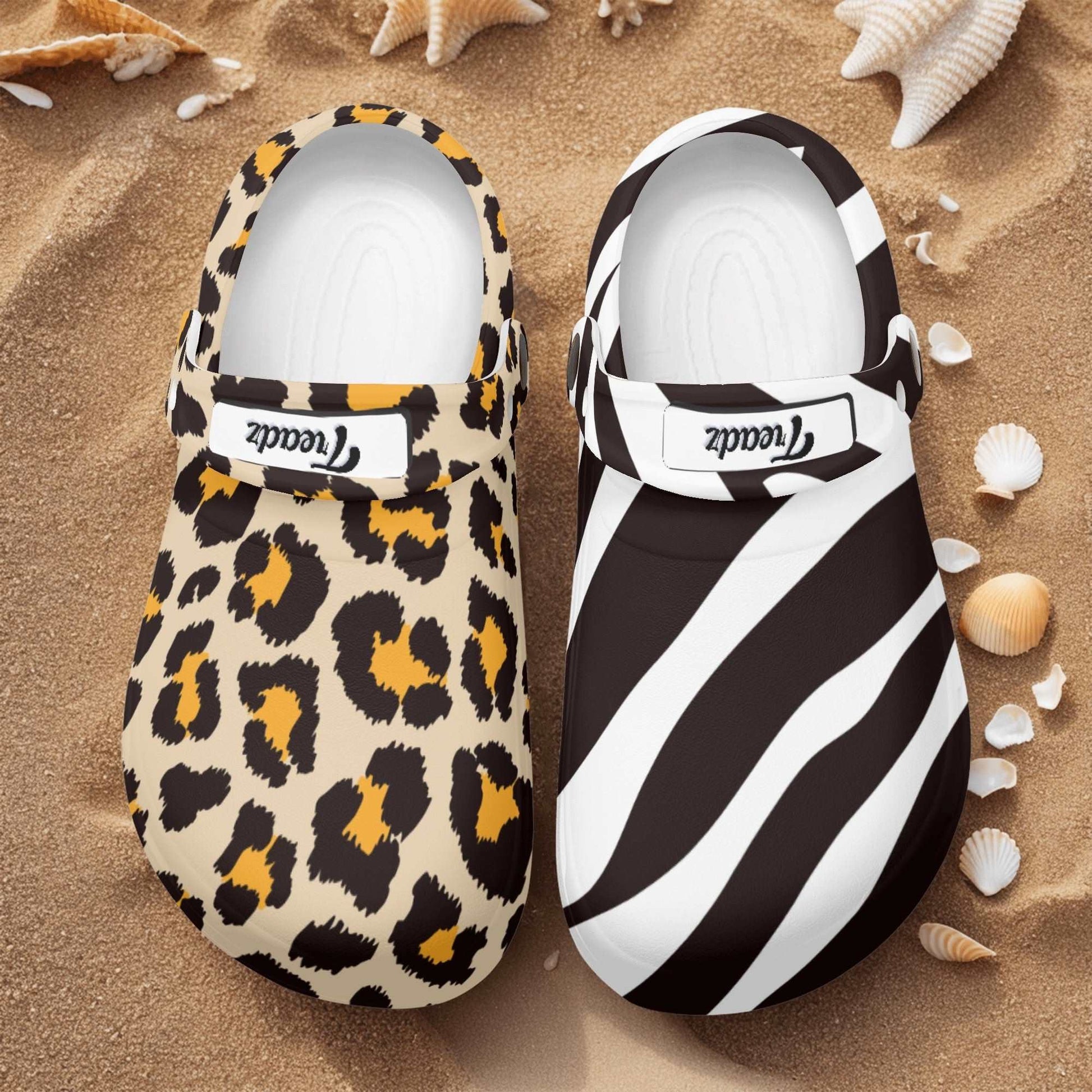 Treadz Nursing Slide On Mismatch Clogs - Safari featuring mismatched leopard and zebra prints on sand background with seashells, showcasing unique nursing clogs with contrasting animal patterns in black, white, and tan colors