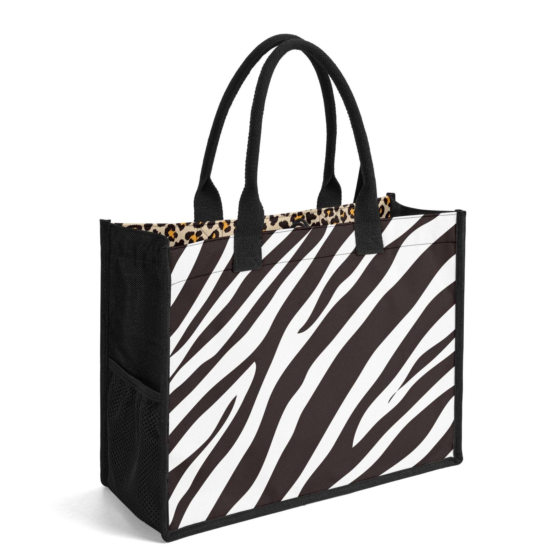 The Mismatch Tote Bag - Safari featuring dual-sided animal prints with zebra stripes on one side and leopard trim, black handles, and mesh side pockets on a sturdy canvas construction