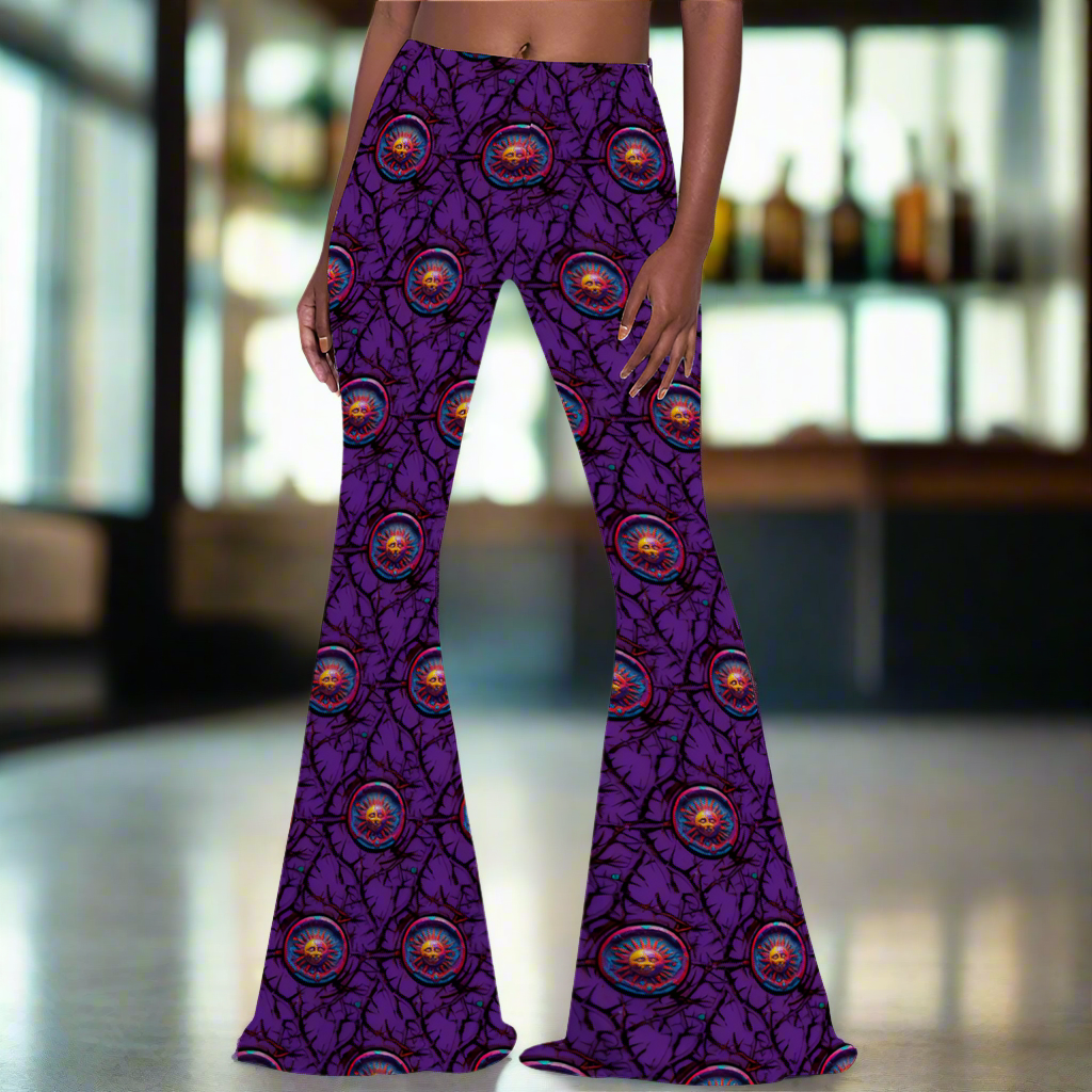 Stretch Bell Bottom Flare - Lunar Anarchy Purple pants featuring a vibrant purple background with repeating circular eye-like designs and black branch patterns. The pants have a fitted waist that flares dramatically at the legs, showcasing the all-over print pattern in a retro-inspired silhouette.