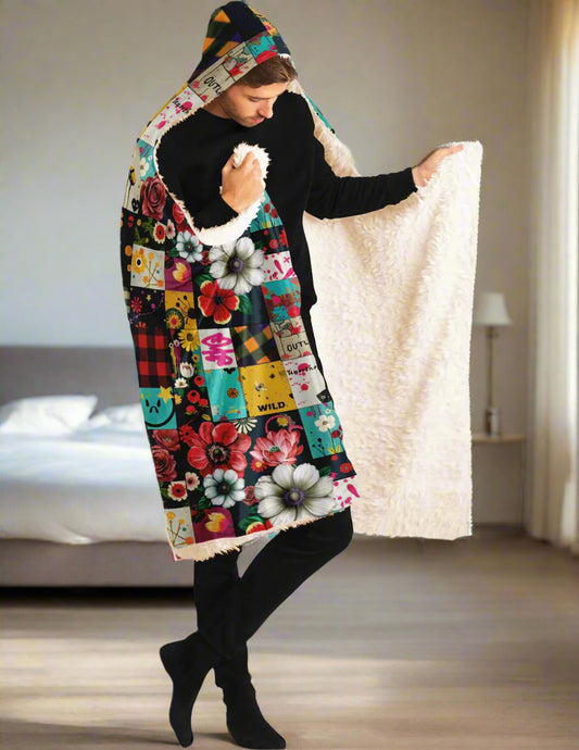 Hooded Blanket 60"x50" - Patched Punk featuring vibrant patchwork design with colorful floral prints, buffalo plaid squares, and artistic patterns on soft fleece material. Cozy white sherpa lining visible as blanket is held open to display full pattern. Perfect for indoor lounging and staying warm.