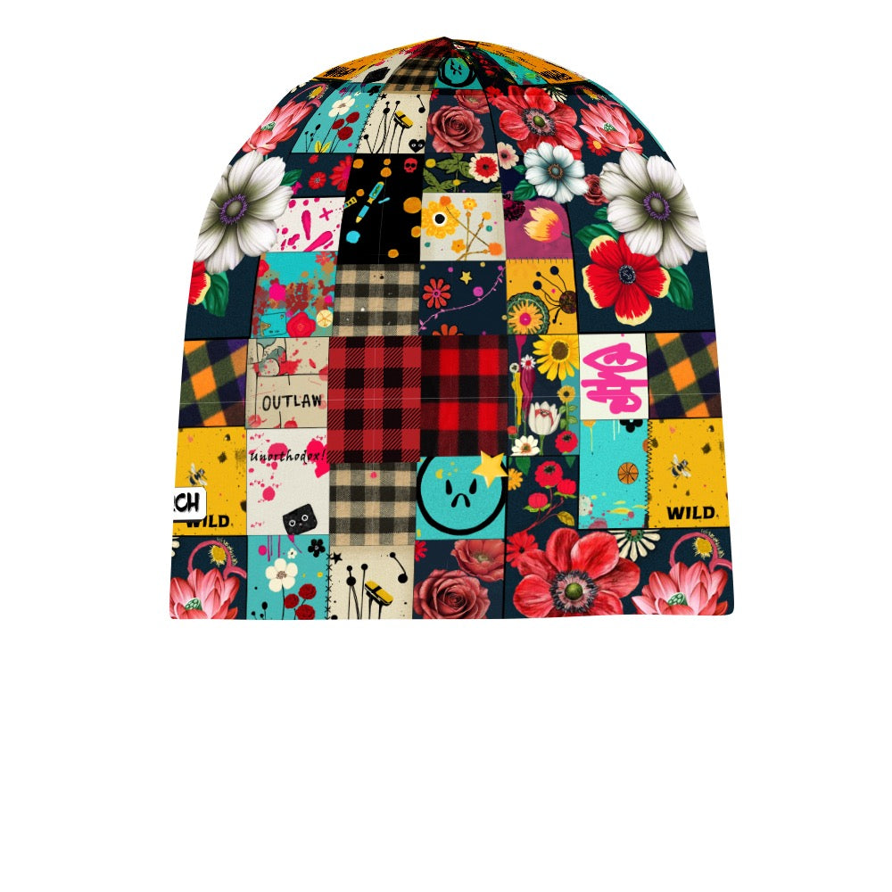 Skull Cap Beanie - Patched Punk featuring a vibrant patchwork design with floral prints, buffalo plaid, and fun graphics. Multicolored beanie with red roses, white daisies, yellow sunflowers, and turquoise accents on a black background. Punk-inspired pattern mixing with outlaw and wild text elements.