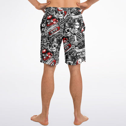 Rip Tide Men's Board Shorts featuring edgy black and white skeleton pattern with red accents, cassette tapes, and Gothic elements. Elastic waistband board shorts displayed on model wearing them at waist height, showcasing the all-over print design and knee-length cut.