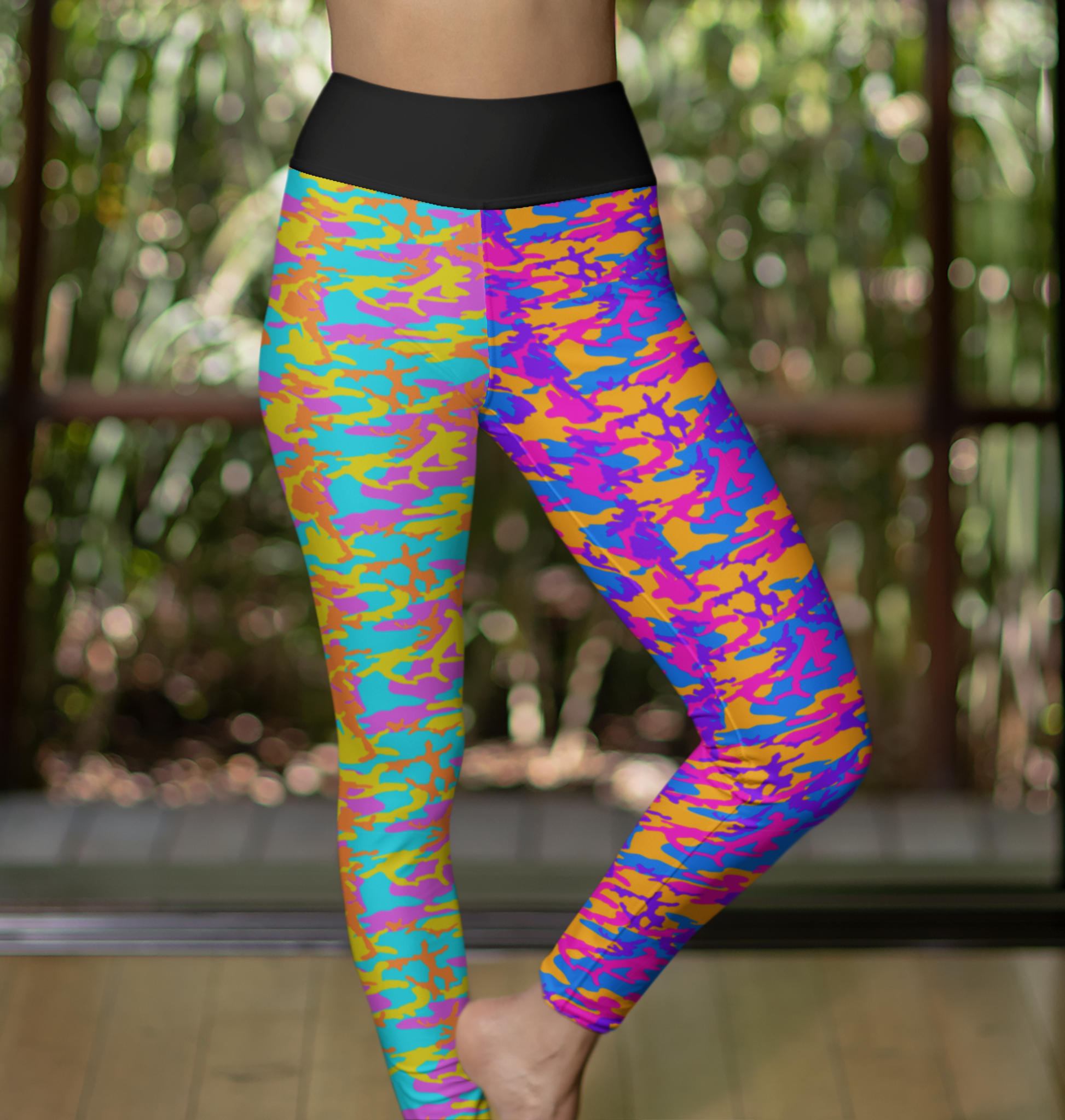 High Waisted Mismatch Core FX Mismatch Leggings - Camo shown in vibrant multicolor design featuring contrasting neon camo patterns in purple, orange, blue, and yellow with a black elastic waistband, photographed against a natural outdoor backdrop with bokeh lighting effects.