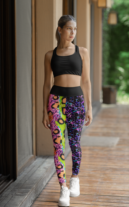 High Waisted Mismatch Core FX Leggings in Modern Leopard pattern shown styled with black sports bra. Vibrant split design features colorful leopard print with pink, purple, and neon yellow accents. High-waisted fit with wide elastic band. Displayed in athletic setting with white sneakers.