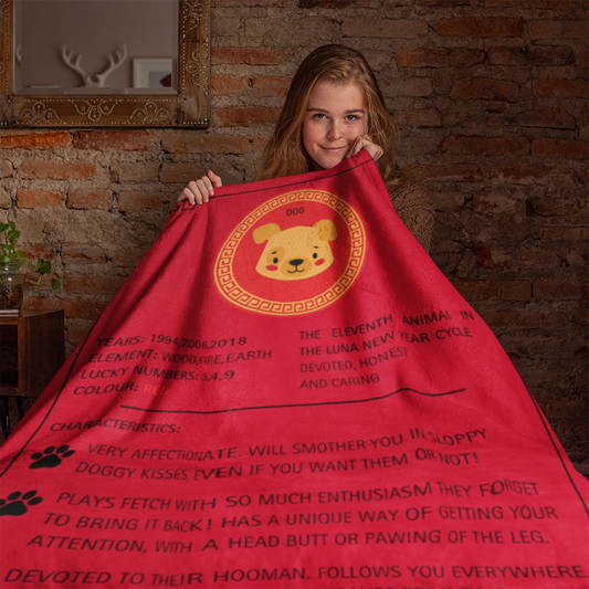 A vibrant red sherpa fleece blanket displaying a cute dog zodiac design with golden Chinese pattern circle and black text describing Dog zodiac traits. Features paw prints and Lunar New Year symbolism. Luna New Year Zodiac Dog Blanket - DOG. ShitHot Best Sellers, Luna New Year Horoscope Blankets.