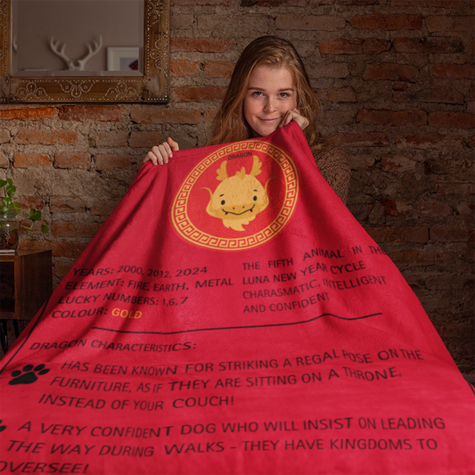 Red sherpa fleece blanket displaying golden Dragon zodiac design with Chinese New Year symbols and text describing Dragon dog traits, shown against brick wall background - Luna New Year Zodiac Dog Blanket Dragon | ShitHot Best Sellers, Luna New Year Horoscope Blankets