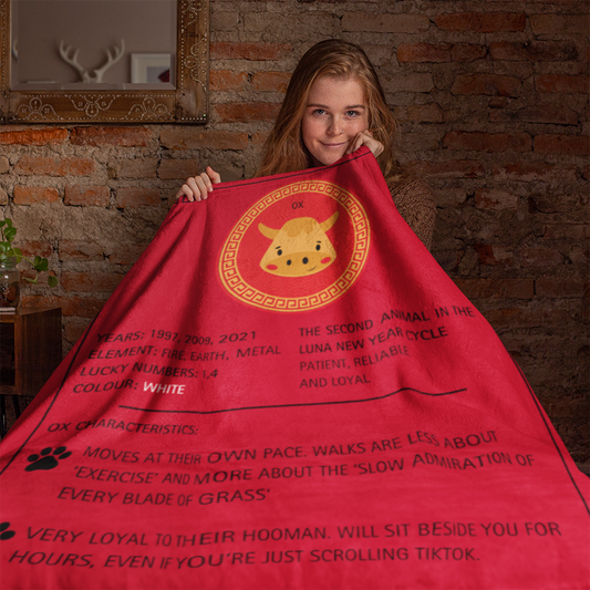 Red sherpa fleece blanket featuring cute Ox zodiac design with golden circular pattern and black text describing Ox characteristics - Luna New Year Zodiac Dog Blanket Collection, ShitHot Best Sellers